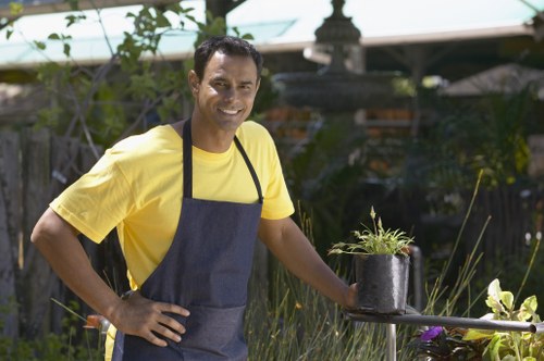 Gardener pruning a shrub in a well-kept garden
